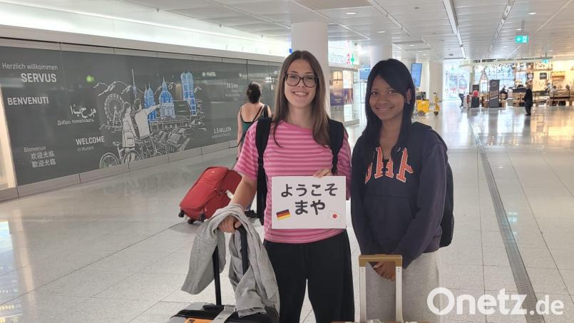 Sarah (links) empfängt Maya am Flughafen in München – natürlich mit einem Schild auf Japanisch. Bild: Ollig/privat