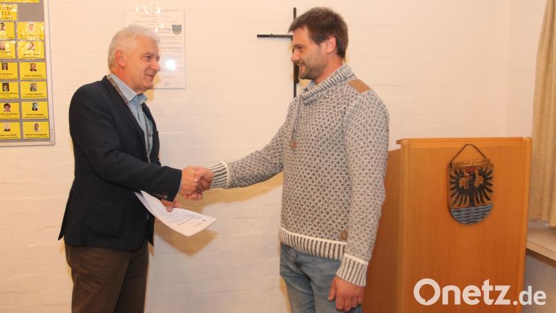 Bürgermeister Robert Lindner (links) begrüßt Frederic Schuller nach der Vereidigung im Marktgemeinderat. Bild: Josef Pilfusek