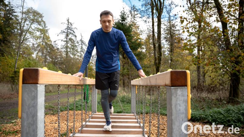 Volontär Jonas Storch bei einem seiner ersten Versuche auf dem Wackelsteg im "Natur-Fit-Pfad" in Großbüchlberg. Die Balken sind in alle Richtungen beweglich. Bild: Erik Glaubitz