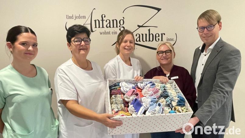 Burgi Zielbauer (Zweite von rechts) überreichte eine Kiste mit 220 Paar gestrickten Söckchen und Schühchen an die Station 32 des Klinikums Weiden. Darüber freuen sich Klinikdirektor Stephan Schumacher (rechts) sowie (von links) Schwesternschülerin Lara Trinkner, stellvertretende Stationsleiterin Jacqueline Kleber und Oberärztin Dr. Ines Erhardt. Bild: Friedrich Peterhans, KNO