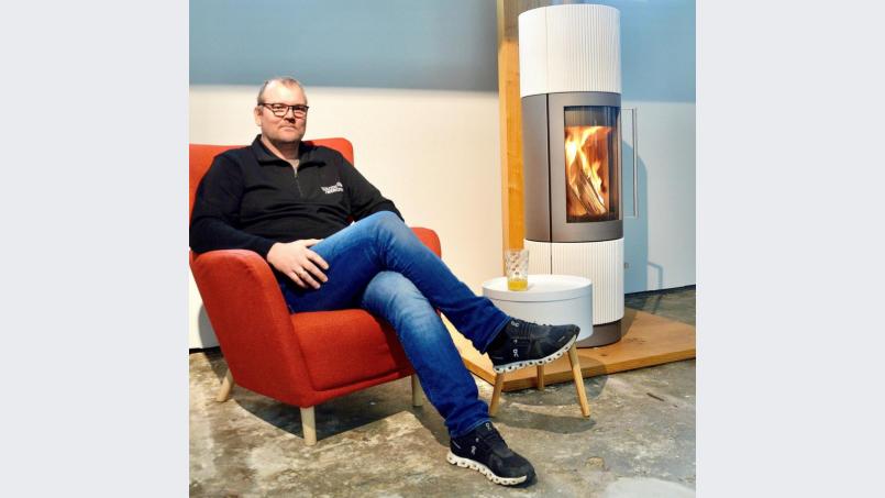 Andreas Koschemann zeigt es: In einem Raum mit Kaminofen lässt sich herrlich entspannen. Bild: mia