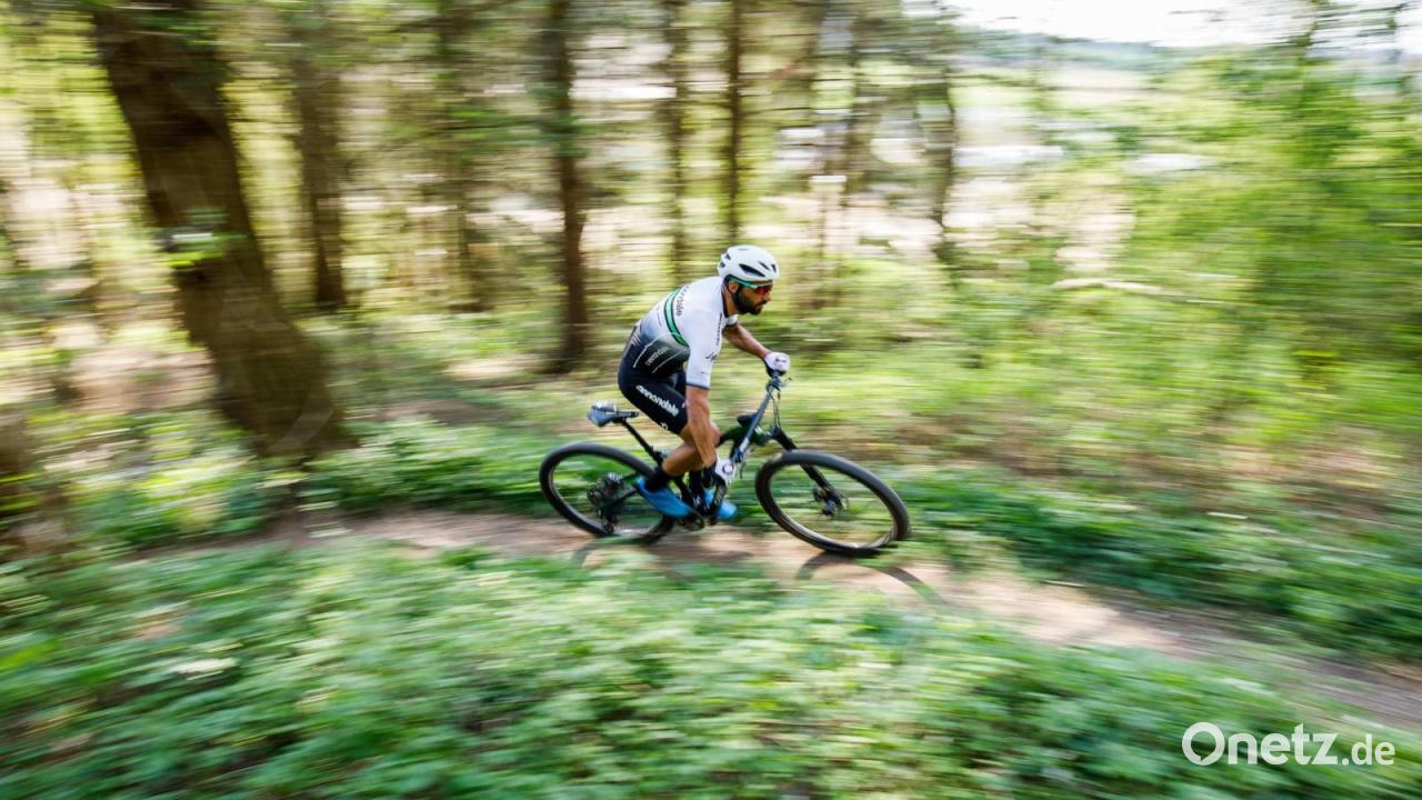 Radfahrer-f-hrt-in-Kastl-gegen-Holzstapel