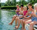 Immer die Finger am Smartphone: Am Freitag kühlten sich die Königsteiner im Naturbad ab und stimmten im Netz für ihre Heimat ab, damit das Bayern-3-Dorffest kommt.	Bild: Hartl