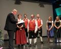 Bezirkstagspräsident Franz Löffler übergibt Vorsitzender Angela Harbauer und Dirigent Stefan Neger den Kulturpreis des Bezirks.