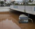 Mehrere Menschen spiegeln sich in der Frontscheibe eines Busses, der bis zum Dach im Wasser steht. Überschwemmungen haben in Griechenland mehrere Menschenleben gefordert.	Bild: Petros Giannakouris/AP/dpa