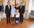 Regierungspräsident Axel Bartelt zeichnete Cailan Voyle (von links) als Lebensretter aus. Mit ihm waren Mutter Korina und Schwester Lauren sowie Bürgermeister Roland Grillmeier zur Ehrung nach Regensburg gefahren. 

	Bild exb/Roth, Regierung der Oberpfalz