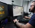 Dominik "Semmel" Hühn ist im Tunnel. Bedeutet: Für den Tirschenreuther gibt es jetzt nur noch die Maus, die Tastatur und das Spiel. Auf dem linken Bildschirm prangt das Logo seiner E-Sport-Organisation.	Bild: Julian Trager