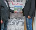 Bild: kö
Hans Baumer (rechts) übergibt das erste druckfrische Exemplar seines Fotobuches an Bürgermeister Georg Köppl.