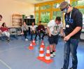 Bild: Petra Hartl
Die Schüler haben die Aufgabe, einer Klebeband-Linie auf dem Boden zu folgen, die als Straße fungiert. Die Pylonen stellten Bäume dar.