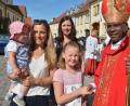 Bild: jr
Bischof Moses begrüßt vor dem Pfarrhof zahlreiche Eltern mit ihren Kindern und spendet den Segen.