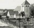 Bild: Archivbild
Fronleichnam 1954:. Die Straße ist mit Birken geschmückt und mit Schilf bedeckt. Rechts ist der spätere Schulgarten zu sehen. Einige Parzellen sind noch unbebaut. Die Kirche wurde im August 1951 eingeweiht.