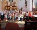 Bild: bsc
Mädchen und Buben des Kinderhauses Friedenfels gestaltete zusammen mit Priester Siegfried Wölfel (hinten) einen Familiengottesdienst und verabschiedete sich vor der gesamten Kirchengemeinde in die Ferien. Kindergartenleiterin Nicole Lippert (hinten Mitte) dankte den Geistlichen.