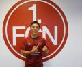 Bild: exb
Yuya Kubo vor dem Club-Emblem: Der Japaner wurde für die Kreativabteilung des Bundesligaaufsteigers verpflichtet.