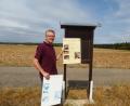 Bild: bk
Rudi Prölß vor dem Anbringen der sanierten Schautafel, zu Füßen die alte Tafel.