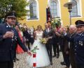 Bild: sl
Das Brautpaar Heide Zitzmann und Patrick Fuchs beim Durchschreiten des Rosenspalier der Feuerwehr Lerau mit Vorsitzenden Peter Schwabl (links) und der Vereinsfahne