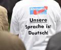 Bild: Lino Mirgeler/dpa
Ein Anhänger der AfD trägt ein T-Shirt mit dem Aufdruck "Unsere Sprache ist Deutsch!".