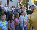 Bild: jr
Weihbischof Dr. Josef Graf segnet Kinder vor der Pfarrkirche.