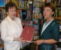 Bild: gis
Beim kleinen Empfang in der Bücherei
Leiterin Selma Markhof, rechts, und Namensgeberin des „Bücherstadls“ Marianne Specht zeigen das allererste Buch der Pfarrbücherei, "Vom goldenen Rom zur Welt". Es sollte in jeder Familie im Regal stehen. So wünschte es sich der damalige Pfarrer Anton Winkler.