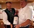 Bild: kb
Bürgermeister Uli Gamper (links) überreicht zum Abschied an den Etzenrichter Bürgermeister Martin Schregelmann eine überdimensional große Flasche Algunder Wein.