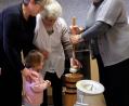 Bild: wlr
Da schaut die kleine Lena, wie aus der Sahne plötzlich Butter wird. Unter Anleitung der mittlerweile 92- jährigen Erika Orlik (Zweite von rechts) hat Anna Schiesl (rechts) den Stampfer für das Butterfass in Bearbeitung.