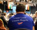 Symbolbild: Sebastian Willnow/dpa
Ein Teilnehmer eines Landesparteitages der sächsischen AfD trägt hier ein T-Shirt mit dem Aufdruck „Unser Land Unsere Regeln“. 	Sebastian Willnow/dpa