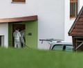Bild: Armin Weigel
Beamte der Spurensicherung betreten ein Wohnhaus, vor dem ein Leichenwagen steht.