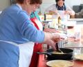 Bild: Renate Scherer-Mende
Hauswirtschaftsmeisterin Roswitha Hubmann erklärt den Kochkurs-Teilnehmerinnen und -teilnehmern, wie man Pfannkuchen in der Pfanne zubereitet, ohne dass sie kleben bleiben.