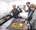 Bild: Hirsch
Der druckgrafische Künstler Bernd Hofmann (links) führte Marie Luise Pfeifer und deren Sohn Daniel aus Nabburg in die Geheimnisse des Siebdruckverfahrens ein.
