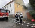 Bild: Julian Fischer
Aus dem Übungsobjekt raucht es. Die Feuerwehrmänner legen die Atemschutzgeräte an, um einen Innenangriff zu starten.