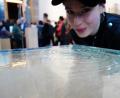 Bild: exb
Miriam Ferstl pustet auf die Wasseroberfläche der gläsernen Skulptur, die von Yoko Ono für das "Water Event" in Leipzig ausgewählt wurde.