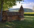 Bild: upl
Die Kirche aus Brennholz vor dem Johannisberg (im Hintergrund). Auf dem Berg steht ein Gotteshaus, das dem Kunstwerk ganz ähnlich sieht.