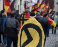 Bild: Arno Burgi/dpa
Ein Mann mit einer Fahne mit dem Logo der "Identitären Bewegung" bei einer Demo in Sachsen.