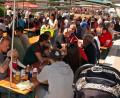 Bild: zer
Dicht gedrängt sitzen die Besucher unter den schattenspendenden Zeltplanen auf dem Dorfplatz.