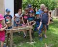 Bild: gru
Die Kinder beim Einschlagen der spitzen Zähnen für einen Rechen im Hintergrund Margarete Jäckel die Besitzerin des Goglhof