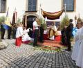 Pfarrer Sven Grillmeier zieht mit dem Allerheiligsten durch die Straßen und macht an einem geschmückten Altar Halt.