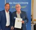 Bild: Bayerisches Staatsministerium für Umwelt und Verbraucherschutz
Umweltminister Thorsten Glauber (links) überreicht Günter Klein aus Trabitz die Auszeichnung "Grüner Engel".