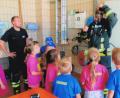 Bild: tu
Zwei Feuerwehrmänner zeigen den Kindern Ausrüstungsgegenstände im Feuerwehrhaus.