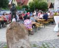 Bild: fm
Der Kletterer schaut den Haunritzern vom Gipfel des Brunnens aus bei ihrem Dorffest zu.