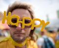 Bild: Ben Birchall
Ein Besucher eines Festivals in Großbritannien mit einer „Happy“-Brille. Foto: Ben Birchall/PA Wire