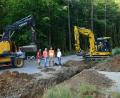 Bild: bey
Zweite Bürgermeisterin Andrea Lang (rechts) und Geschäftsleiter Günter Gschwindler (Zweiter von links) besprechen regelmäßig mit den verantwortlichen Mitarbeitern der Baufirma den Baufortschritt. Der Graben im Vordergrund dient dem Einbau eines neuen Rohrdurchlasses als Ersatz für das veraltete Bauwerk.