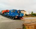 Bild: Hösamer
Gut 55 Meter und rund 546 Tonnen schwer lang ist der Schwerlastzug, der am Montagabend vom Müllkraftwerk durch die Alustraße (Bild) Richtung Umspannwerk Büchelkühn rollt. Transportiert wird ein 273 Tonnen schwerer Trafo, der in einem Tieflader mit Tragschnäbeln (rot) auf zwei jeweils 13-achsigen, je 700 PS starken Zugmaschinen ruht.