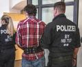 Bild: Armin Weigel/dpa 
Der Angeklagte wird von Polizisten in den Verhandlungssaal des Landgerichts geführt.