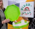 Bild: Daniel Karmann/dpa
Cornelia Fehlner von der Nürnberg Messe präsentiert das "Pizzabow". Ein Mehrwegsystem bestehend aus stapelbaren Kunststoffschalen, in denen sich ein Papptablett befindet. Der größte Teil der Pappe eines herkömmlichen Kartons wird somit überflüssig. Das Papptablett wird bei der Lieferung entnommen und behalten, die Schale wird wieder mitgenommen und wiederverwendet.