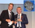 Bildmontage:  Kaulard/Biermann Medizin
Frranz Badura (rechts) nimmt von DOG-Präsident Prof. Claus Cursiefen die Theodor-Leber-Medaille entgegen.