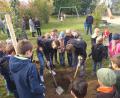 Bild: extern
Der Apfelbaum wird mit vereinten Kräften am Spielplatz eingesetzt.
