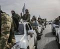 Bild: Anas Alkharboutli/dpa
Mitglieder der von der Türkei unterstützten Syrischen Nationalarmee warten auf ihren Fahrzeugen nahe der türkischen Grenze.