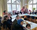 Bild: exb/Arbeit und Leben in Bayern gGmbH
Den Frauen über Integration berichten (stehend, von links) Andrea Eich und Kursleiterin Nermin Khedr.