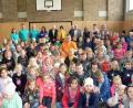 Bild: lep
Mitten in der Schulfamilie - im Hintergrund Elternbeirat, Verwaltung und Lehrkräfte - nimmt der neue Hausmeister Lucas Lohner auf einem purpurroten Stuhl Platz. Seit 1. August kümmert er sich um die Belange der Schule.