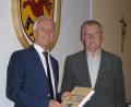 Bild: öt
Autor Hans Enders (rechts) übergab bei seiner Buchvorstellung das erste Exemplar des Buches „Schwarzenreuth – Geschichte und Geschichten“ an Bürgermeister Peter König.