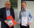 Bild: Bühner
Stolz präsentiert Lukas Dausch als deutschlandweit bester Azubi im Güterzugbereich seine Auszeichnungen. Vom Leiter DB Cargo Nordostbayern erhält er ein Buchgeschenk.